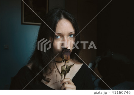 girl looking at camera with a dry rose girl looking at camera with a dry rose 41160746