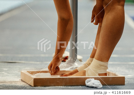 female gymnast rubs chalk on his legs 41161669