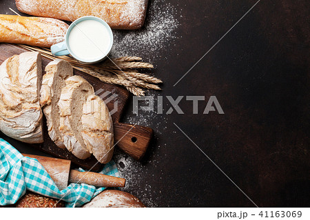 Various crusty bread and cup of milk 41163069