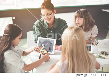 Positive teacher and children creating toy Positive teacher and children creating toy 41169141