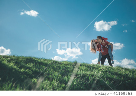 Girl on back of boyfriend in nature Girl on back of boyfriend in nature 41169563