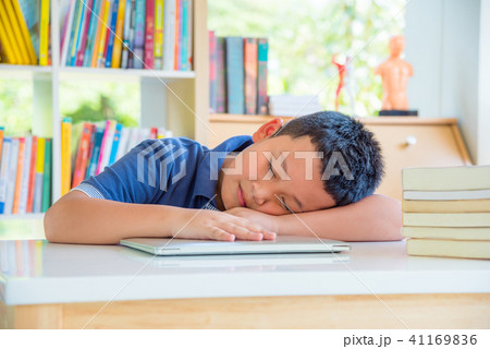Young schoolboy fall asleep in school library Young schoolboy fall asleep in school library 41169836