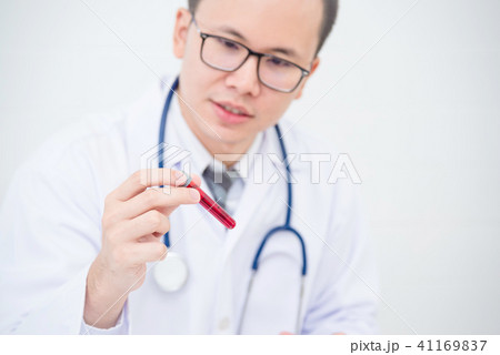 doctor holding and looking at patient blood tube doctor holding and looking at patient blood tube 41169837