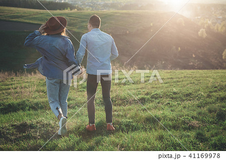 Couple walking on green hill in warm summer evening 41169978