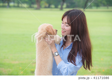 Beautiful girl smiling with her little dog in park 41171086