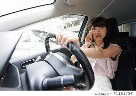スマホを使いながら運転する女性 スマホを使いながら運転する女性 41181754