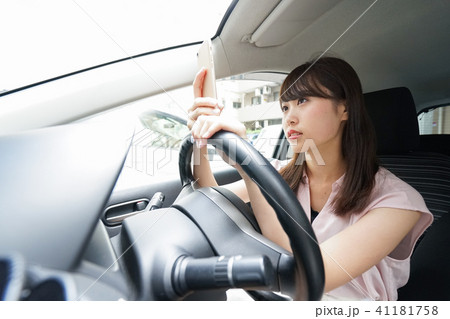 スマホを使いながら運転する女性 スマホを使いながら運転する女性 41181758