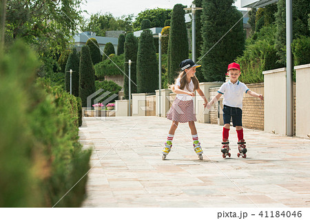 Portrait of a charming teenage couple roller-skating together 41184046