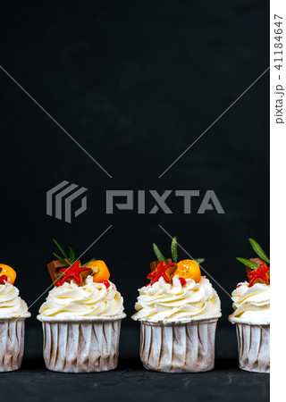 Baked Cupcakes with chocolate and biscuits on a black background. Free space for text. Close-up view 41184647
