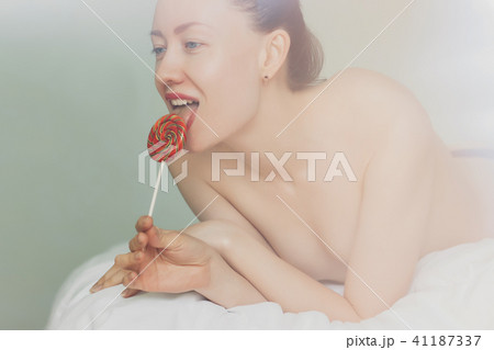 Alluring nude woman licking lollipop 41187337