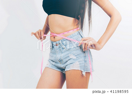 Slender woman measuring her waist with metric tape measure after a diet,  isolated 16406784 PNG