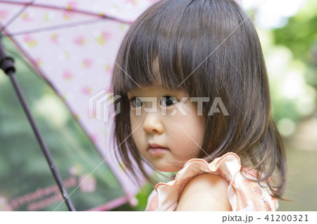 傘をさす2歳の女の子の写真素材