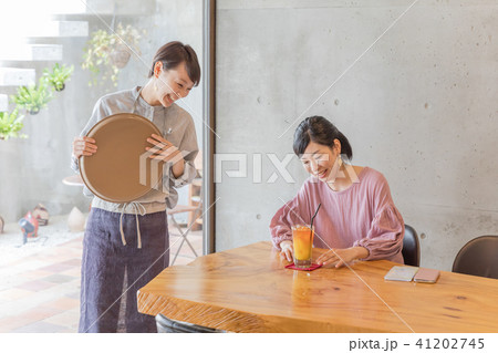 カフェ 女性スタッフとお客 カフェ 女性スタッフとお客 41202745