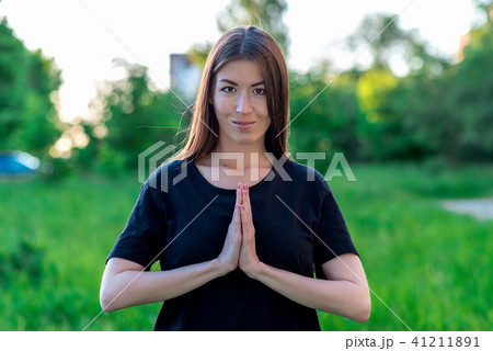 Beautiful young girl in summer in park on vacation. A gesture shows prayer with his hands. Happy Beautiful young girl in summer in park on vacation. A gesture shows prayer with his hands. Happy 41211891