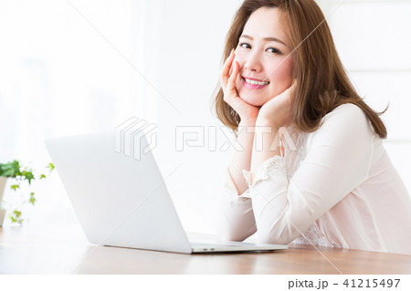 部屋でラップトップコンピューターを見る女性 部屋でラップトップコンピューターを見る女性 41215497