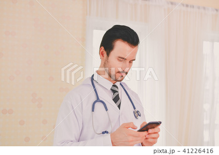 Smiling doctor posing in the office, he is wearing a stethoscope 41226416