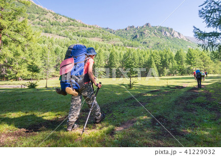 Young woman hiker on a sunny day trekking in high mountains Young woman hiker on a sunny day trekking in high mountains 41229032