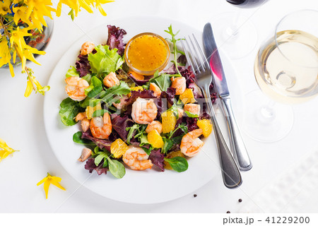 Healthy salad with prawns, lettuce, oranges and mango served on a plate with orange mustard sauce Healthy salad with prawns, lettuce, oranges and mango served on a plate with orange mustard sauce 41229200