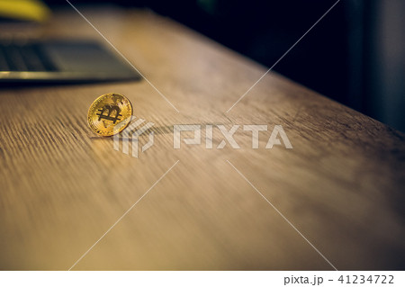 Bitcoin on brown wooden table. 41234722