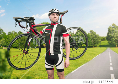 Bycyclist keeps the bike on shoulder after biking 41235441