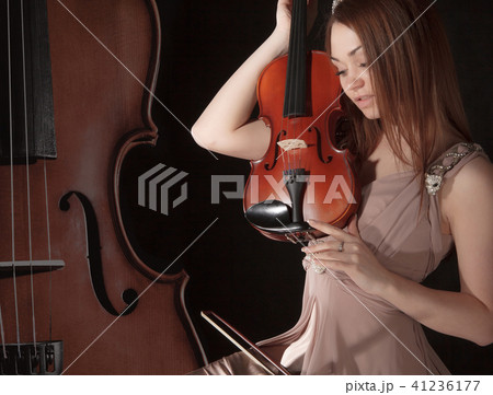 Pretty young woman holding a violin 41236177