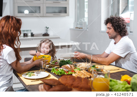 Happy father and mother feeding her child by healthy food Happy father and mother feeding her child by healthy food 41240571