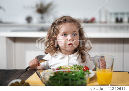 Pretty kid eating healthy vegetables at home Pretty kid eating healthy vegetables at home 41240611