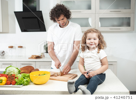 Cheerful kid watching her dad cooking Cheerful kid watching her dad cooking 41240751