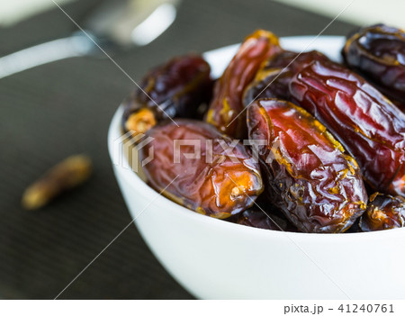 Organic dry dates fruit in small white bowl Organic dry dates fruit in small white bowl 41240761