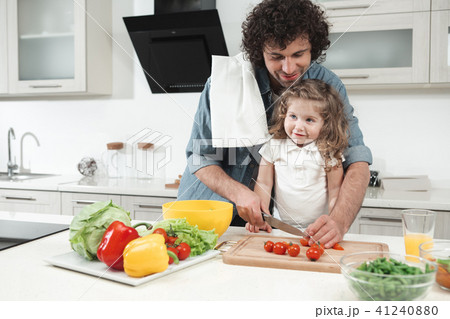 Cheerful parent teaching his child to cook  41240880