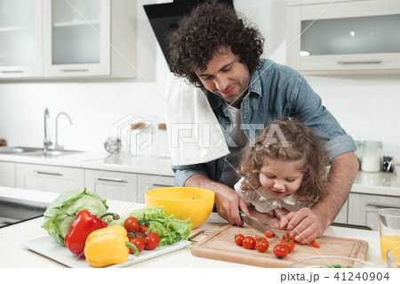 Curious daughter is looking how her dad preparing lunch  41240904