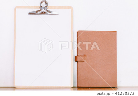 Paper in clipboard and notebook on wooden table 41250272