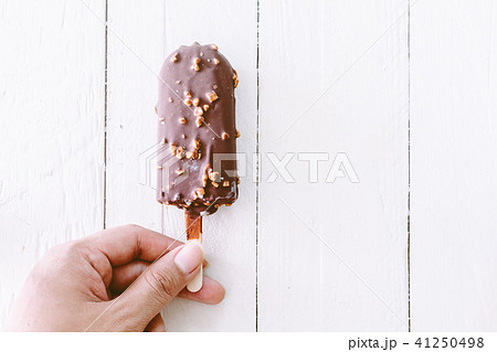 Hand holding bite Ice cream chocolate on wooden  41250498