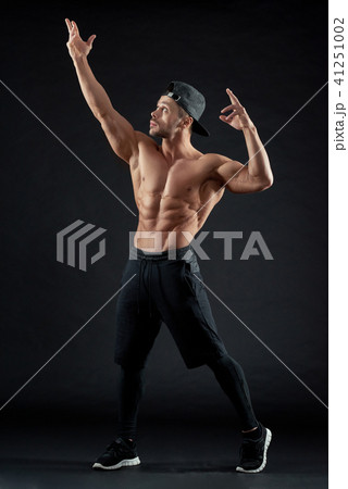 Muscular man with athletic body posing on black background. Muscular man with athletic body posing on black background. 41251002