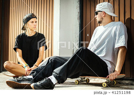 boy and girl on a skateboard are talking with each other 41251198
