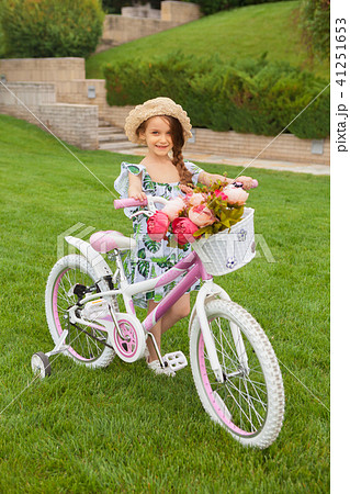 Beautiful little girl riding a bicycle through the park. Nature, lifestyle 41251653