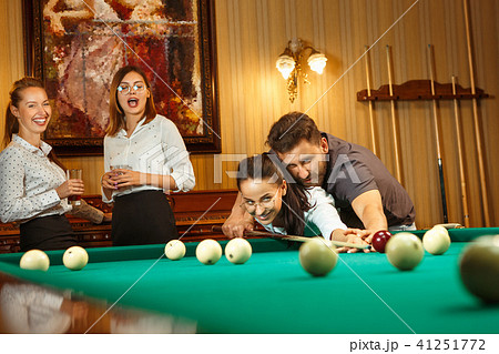 Young men and women playing billiards at office after work. 41251772