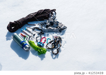Close-up of winter climbing equipment on fresh snow on a sunny day. Carbines with a rope gazebo and 41253439