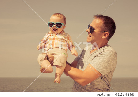 Father and baby son playing on the beach at the day time. Father and baby son playing on the beach at the day time. 41254269