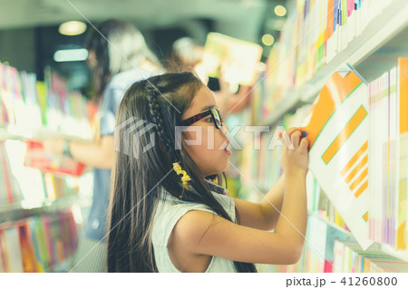 Asian child  picking books from the bookshelf 41260800