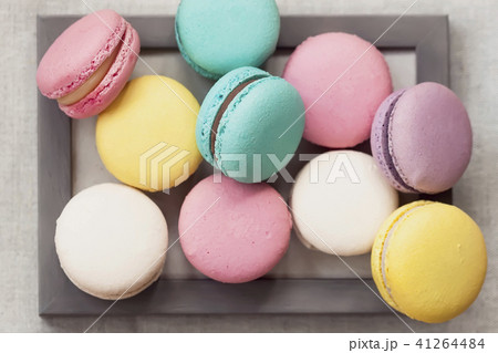 Fresh natural colorful macarons of different tastes in wooden frame, unusual abstract sweet art 41264484