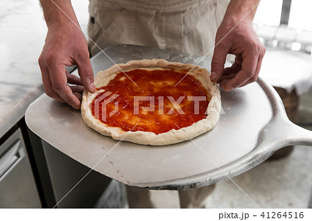 Fresh original Italian raw pizza, preparation in traditional style. Hands of chef baker making pizza 41264516