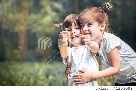girl is sitting on a bench and is reading a book 41265088