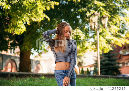 blonde teenage girl in striped blouse on the backgrountd of green tree blonde teenage girl in striped blouse on the backgrountd of green tree 41265215