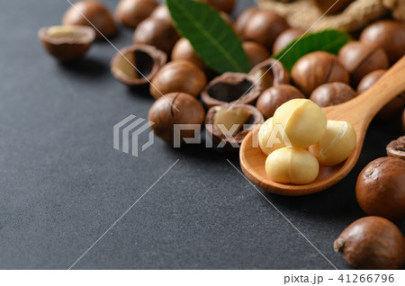 Macadamia nuts on wood spoon on black stone 41266796