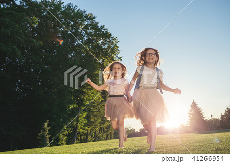 Two joyfull girls running against the sunset. 41266954