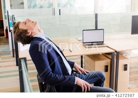 Young tired businessman resting at workplace 41272507