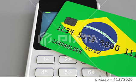 Payment or POS terminal with credit card featuring flag of Brazil. Brazilian retail commerce or 41275020