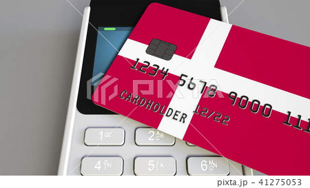 Payment or POS terminal with credit card featuring flag of Denmark. Danish retail commerce or 41275053