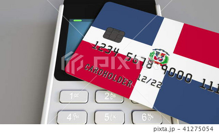 Payment or POS terminal with credit card featuring flag of the Dominican Republic. Retail commerce 41275054